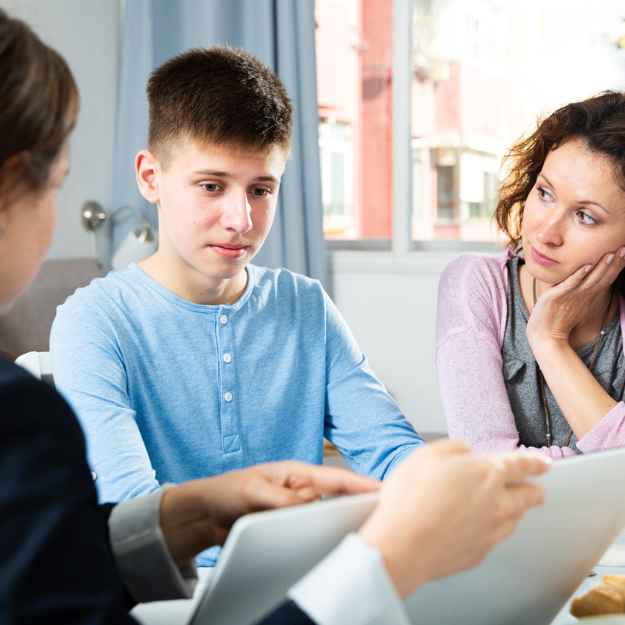Teenager and his mother listening at an IEP meeting